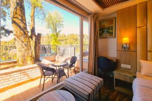 a room with a balcony with a table and chairs at Katson Blue Dalhousie in Dalhousie