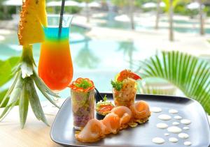 a plate of food on a table with a drink at Beach Walk Apartment with Private Garden & Wifi in Grand-Baie