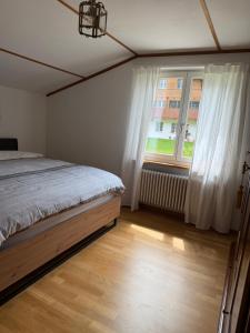 a bedroom with a bed and a large window at Mountain and Lake in Bönigen