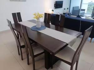 a dining room table with chairs and a vase with flowers on it at Playa Blanca Ocean ll in Playa Blanca