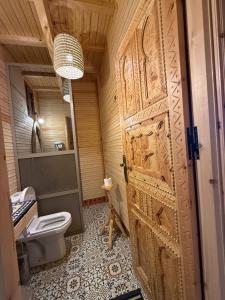 a bathroom with a toilet and a wooden door at Jnane Karma in Imlil +174 photos