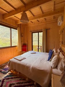a bedroom with a large bed in a room with windows at Jnane Karma in Imlil