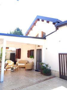 a white house with a patio with chairs and tables at La Mansarda nel Borgo in Borgo Venusio