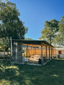 a wooden pavilion in a field with trees in the background at Camping Rio do Rastro in Lauro Müller