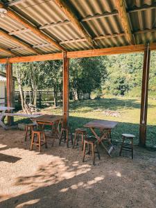 a group of picnic tables and chairs under a pavilion at Camping Rio do Rastro in Lauro Müller