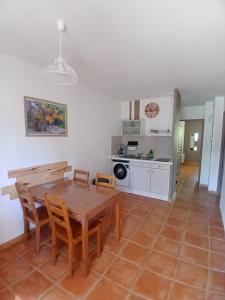 a kitchen and dining room with a wooden table and chairs at Maison dans village de vacances 5 pers climatisé piscine in Gaujac