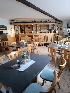 a restaurant with tables and chairs and a counter at Hotel Pension Vineta Rügen in Baabe