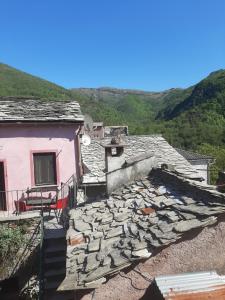 a house with a stone roof with mountains in the background at Medieval Village Rural B&B in Ne