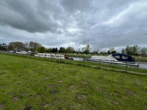 a boat is docked next to a grass field at Pop Bell tent in Radcot