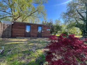 a small wooden cabin with two doors in a yard at Pop Bell tent in Radcot