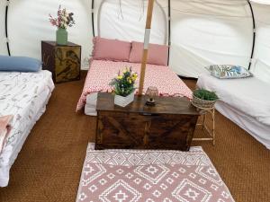 a room with two beds and a table in a tent at Pop Bell tent in Radcot