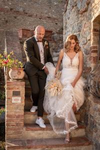 a bride and groom are sitting on the stairs at Antica Dimora in San Gimignano