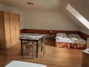 a dining room with a table and chairs and a bed at Penzion Leona in Obecnice +7 photos