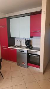 a kitchen with red cabinets and a stove top oven at CasArcieri mare in Barletta