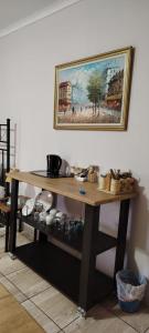 a wooden table with a painting hanging on a wall at Drakensberg Rest in Kimberley