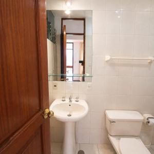a bathroom with a sink and a toilet and a mirror at Killaqente in Cusco