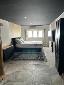 a bedroom with a bed and a window and a rug at Royal SPA Saarbrucken in Stiring-Wendel