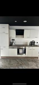a kitchen with white cabinets and a stove at Royal SPA Saarbrucken in Stiring-Wendel
