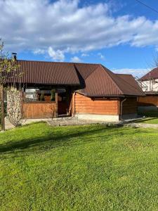 a building with a brown roof on a grass field at VIGORA in Verkhovyna