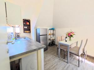 a kitchen with a table and chairs and a refrigerator at ESPRESSO VISTA MARE, Ostia Antica in Lido di Ostia