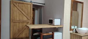 a kitchen with a door and a microwave on a counter at Drakensberg Rest in Kimberley +11 photos
