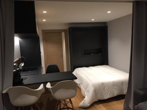 1 dormitorio con 1 cama, escritorio y sillas en Studio proche pistes Chantemerle, en Saint-Chaffrey