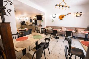 a restaurant with tables and chairs and a couch at Hotel et Résidence Cala di sole in Porto Ota