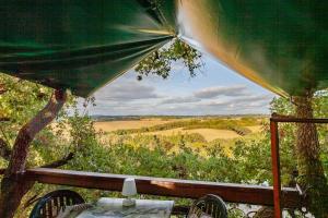 a table and chairs with a view of a field at B&B La Cabane Insolite in Monès +17 photos