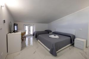 a bedroom with two beds and a television in it at Dimora Ambrosio 108 in San Giuseppe Vesuviano