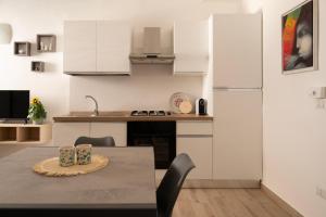a kitchen with a table and a white refrigerator at Sarmalia 32 a pochi passi dal centro di Nardò in Nardò