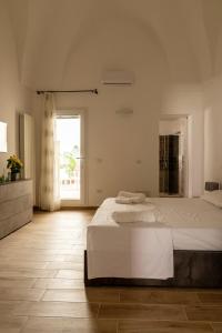 a white bedroom with a large bed and a window at Sarmalia 32 a pochi passi dal centro di Nardò in Nardò