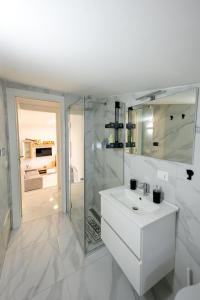 a white bathroom with a sink and a shower at Dimora Ambrosio 108 in San Giuseppe Vesuviano +9 photos