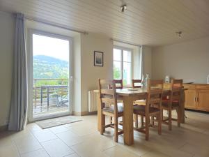 a dining room with a table and chairs and a large window at La Maison Rose - La Bresse in La Bresse