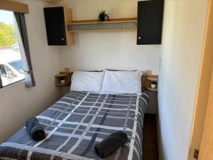 a bedroom with a bed with a blue and white comforter at Cornish Dreams - WiFi in Newquay