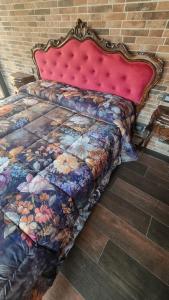 a large bed with a red head board on a brick wall at Natalìa glamour home in Nettuno +46 photos