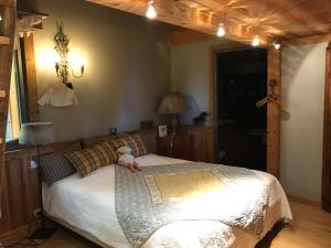 a bedroom with a bed with a teddy bear laying on it at Chalet ANTARÈS in Manigod