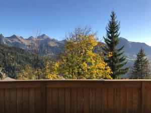 a wooden fence with trees and mountains in the background at Chalet ANTARÈS in Manigod