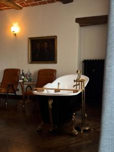 a bath tub in a room with a table and chairs at Relais Conac 1888 - Luxury B&B - Adults Only in Castelnuovo Don Bosco