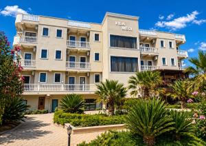 a building with palm trees in front of it at Hotel Villa Megi in Golem