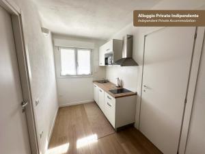 a kitchen with white cabinets and a sink and a window at Isola Chiara in Cagliari