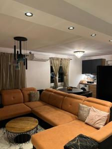 a living room with a brown couch and a kitchen at Apartman NIKOL in Senj