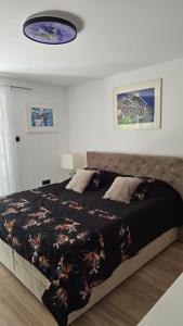 a bedroom with a large bed with a black blanket at Apartman NIKOL in Senj