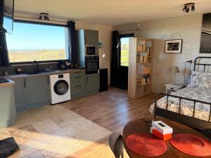 a kitchen and living room with a large window at La Perle Rare in La Barthe