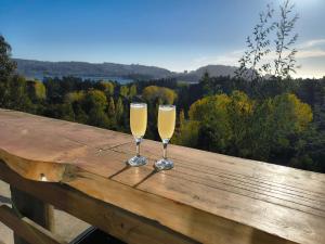 two glasses of champagne sitting on a wooden table at Casa Hotel Los Arrayanes in Constitución +49 photos
