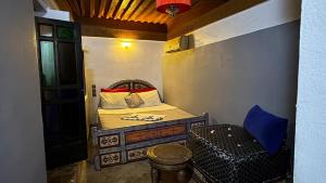 a small room with a bed and a chair at Palais Doha & SPA in Fez +9 photos