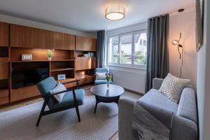 a living room with a couch and chairs and a table at Modernes Ferienhaus Dornbirn mit 2 Schlafzimmern 2 Bädern nahe Bodensee & Bregenzerwald in Dornbirn