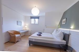 a bedroom with a bed and a desk and a chair at Modernes Ferienhaus Dornbirn mit 2 Schlafzimmern 2 Bädern nahe Bodensee & Bregenzerwald in Dornbirn