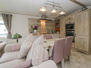 a kitchen with a table and some chairs in a room at Carp Lodge in Carnforth