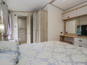 a bedroom with a large bed and a television at Carp Lodge in Carnforth