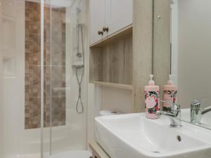 a white bathroom with a sink and a shower at Carp Lodge in Carnforth +27 photos